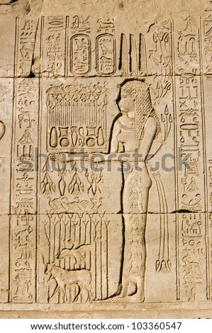 Ancient Egyptian carving on the wall of Dendera Temple of a priestess offering to the goddess Maat.  Ancient carving, over 1000 years old.