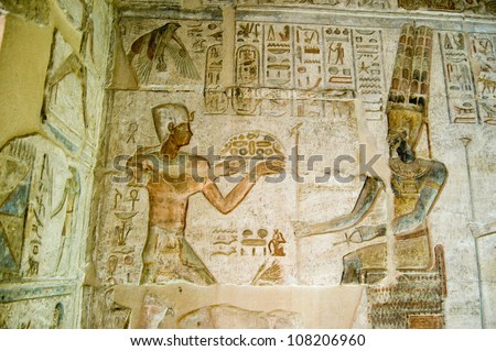 Ancient Egyptian bas relief showing the Pharaoh Ptolemy IV making an offering to Amun.  Deir el Medina temple, Luxor, Egypt. Ancient temple, over 1000 years old.