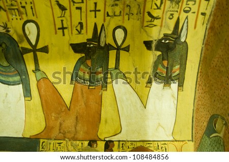 Ancient Egyptian wall painting of Anubis gods sitting holding Ankh keys.  Interior of tomb of Pashedu, TT3 in Deir el Medina, Luxor, Egypt. Ancient tomb over 1000 years old.