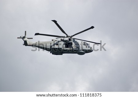 PORTLAND, DORSET, ENGLAND - AUGUST 31: Royal Navy Merlin helicopter flying over Portland Harbour on August 31 2012.  The Royal Navy is protecting events at the Paralympic Games at Weymouth.