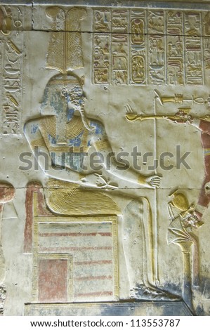 Bas relief carving of the ancient Egyptian god Amun.  Coloured blue with a headdress of ostrich feathers.  Wall of Abydos Temple, near el Balyana, Egypt.  On public display for over 2,000 years.