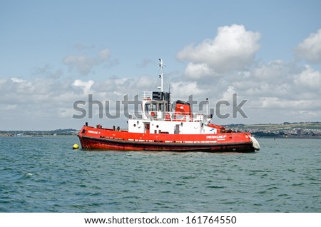 PORTSMOUTH, ENGLAND - AUGUST 2: Tug boat Gwendoline P in Portsmouth Harbour on August 2 2013.  Many large ships including Royal Navy and cross channel ferries use the port and require tug assistance.