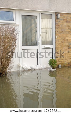 BASINGSTOKE, ENGLAND - FEBRUARY 16 2014: Flood waters reaching up to the front door of a house in Basingstoke, Hampshire after many days of heavy rain.  Residents have been evacuated from the area.