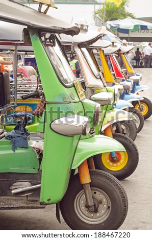 BANGKOK, THAILAND - OCTOBER 27 2013: A row of neatly parked tuk tuk auto rickshaws parked in a row in Bangkok, Thailand