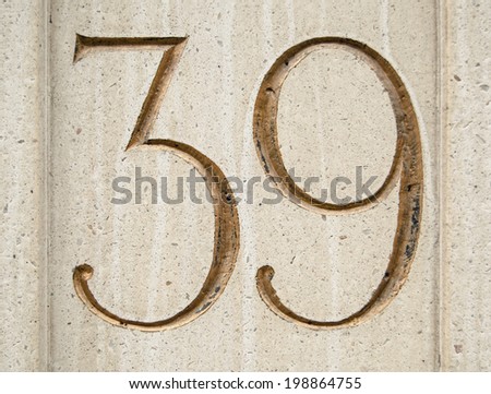 A figure thirty nine carved and gilded in a block of stone on the exterior of an office block in the City of London.
