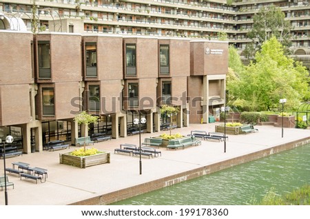 LONDON, ENGLAND - APRIL 12, 2014: View across the ornamental lake in the Barbican complex towards the Guildhall School of Music and Drama in the City of London.