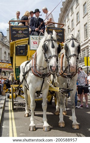 LONDON, ENGLAND - JUNE 22, 2014: A vintage horse-drawn bus, one of the first to offer public transport in London, on display in Regent Street to mark the bicentenary of London buses