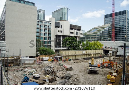 LONDON, ENGLAND - MAY 10, 2014:  Rubble and heavy machinery at a building site on London Wall in the City of London.  Land is very expensive in this part of the city\'s financial district.
