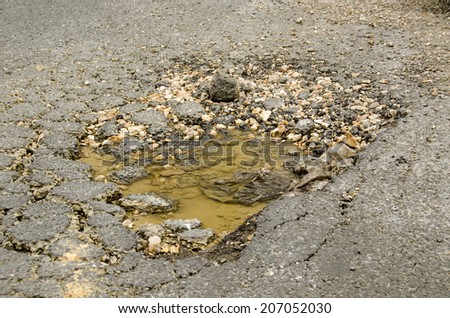 A deep pothole filled with water in a road in Southampton, Hampshire.
