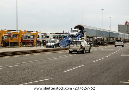 SOUTHAMPTON, UK - MAY 31, 2014:  A train full of newly-built mini cars being unloaded at Southampton Docks.  The cars were being driven straight onto a container ship for export.