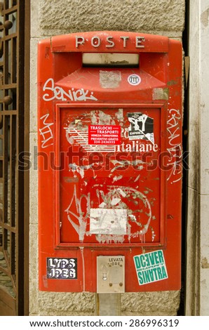 VENICE, ITALY - MAY 24, 2015:  An Italian post box covered in stickers and graffiti on a wall in Lido, Venice.