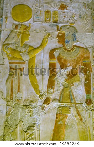 Hathor and Pharaoh Seti Ancient egyptian hieroglyphic carving of the goddess Hathor with an ankh before the Pharaoh Seti I.  Coloured carving on a wall of the Temple of Abydos, Egypt.