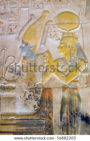 Isis and Osiris carving .  Isis is wearing the horned crown of Hathor.  Inner wall at the Temple to Osiris at Abydos, Egypt.