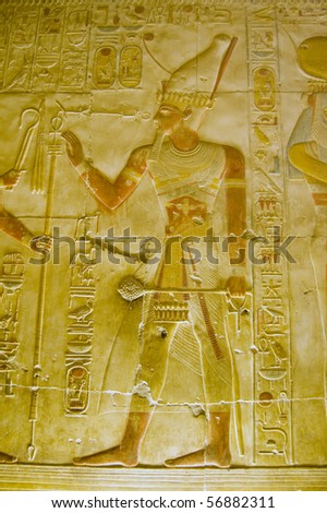 Pharaoh Seti with sceptre A painted Ancient Egyptian hieroglyphic carving showing the Pharaoh Seti carrying a ceremonial club or sceptre.  Inner wall of the Temple to Osiris at Abydos, Egypt.
