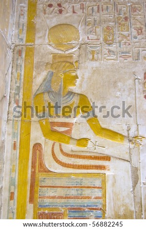 Ancient Egyptian Goddess Isis on her Throne   Painted hieroglyphic carving in an inner wall at the temple to Osiris at Abydos, Egypt.