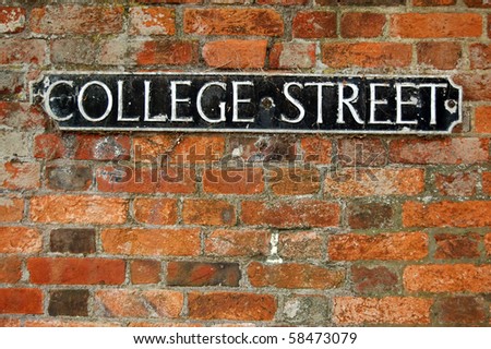 College Street roadsign An old, cast iron road sign for \'college street\' on a warm orange brick wall.  Winchester, Hampshire