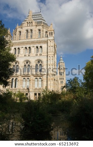 View of the Victorian Natural History Museum in South Kensington, London.  View of the West Wing of the public building from the nature garden and pond.