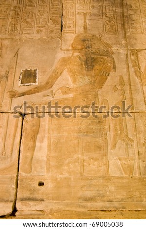 Carved stone frieze of the ancient egyptian god Khnum in human form with a crown of ram\'s horns on his head. Interior of the Temple of Seti I on the West Bank of the River Nile at Luxor, Egypt.