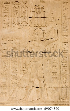 Ancient Egyptian pharaoh killing evil in the form of a snake.  Temple of Horus, Edfu, Egypt.
