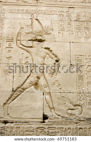 Ancient Egyptian hieroglyphic carving showing the Pharaoh king killing the god of the underworld - Seth - who has taken on the form of a hippopotamus. Outer wall of the Temple of Horus, Edfu, Egypt.