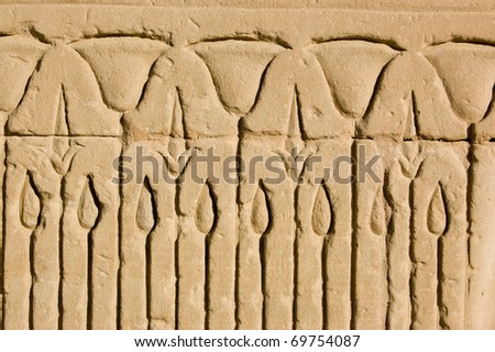 Close-up of an ancient egyptian stone carved frieze of lotus blossoms in a reed bed.  Outer wall of the Temple of Horus, Edfu, Egypt.