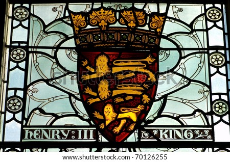 Historic stained glass window showing the coat of arms of the medieval King Henry III of England.