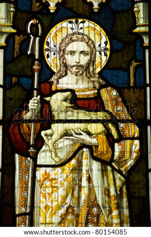 Victorian stained glass window showing Jesus Christ and the lamb of God.