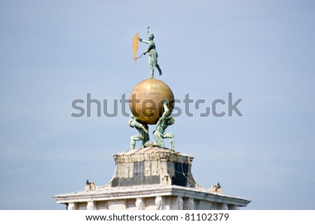 The bronze and golden weather vane on top of the Dogana di Mare in Venice.  Built where the Grand Canal meets the Giudecca Canal the Customs House is now an art gallery.