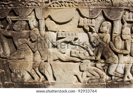 Ancient Khmer carving showing trays of food and drink being carried to a banquet.  Wall of Bayon Temple, Angkor Thom, Siem Reap, Cambodia.