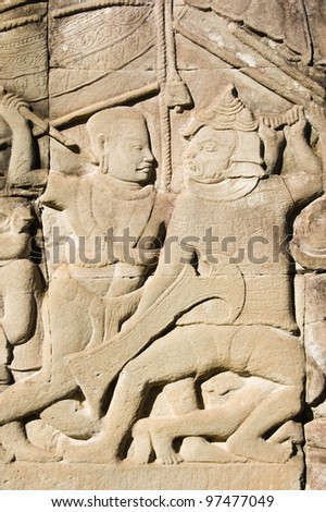 Ancient bas relief carving showing a Khmer and a Cham soldier fighting.  Wall of Bayon Temple, Angkor Thom, Siem Reap, Cambodia.