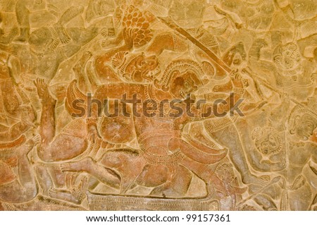 Bas relief showing a scene from the Battle of Lanka between Rama and Ravana as described in the epic Ramayana.  A monkey soldier is fighting a demon.  Wall of Angkor Wat Temple, Angkor, Cambodia.