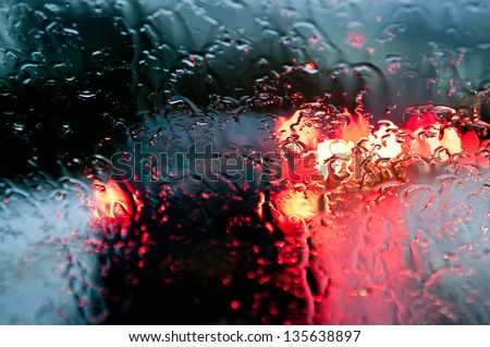 Traffic Stands Still, On A Cold, Wet Day, Shot Through A Windscreen, Focusing On The Rain Droplets, Tailights Out Of Focus