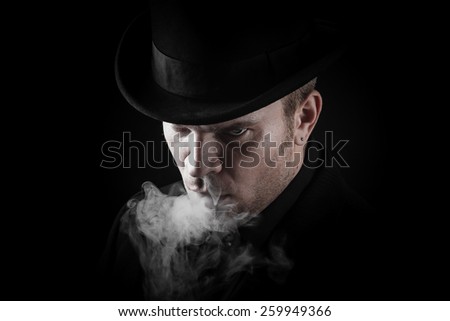 Elegant man standing in smoke in darkness