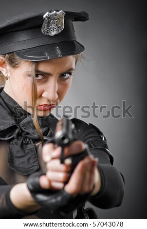 beautiful policewoman aiming a gun on a gray background