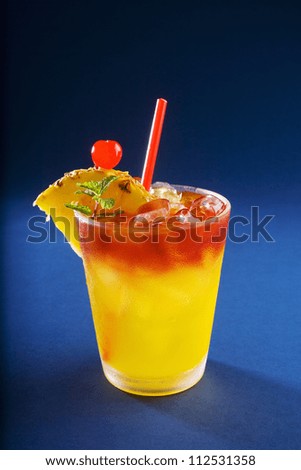 A mai tai cocktail garnished with pineapple and a cherry, studio shot