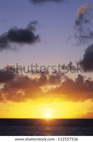 Sun in yellow sky above the ocean surface
