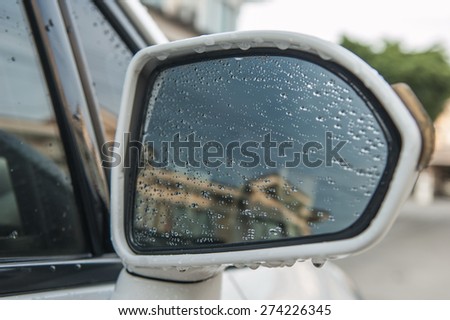 Water droplets on a car side mirror.