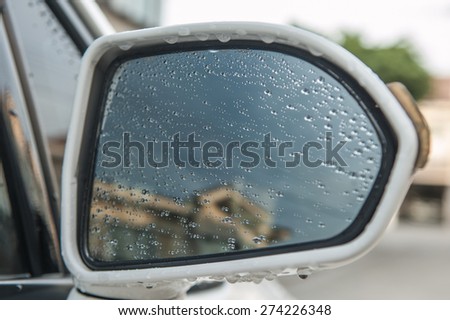Water droplets on a car side mirror.