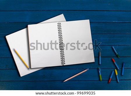drawing book and creyon on wood background