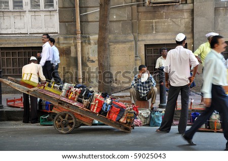 KOLKATA, INDIA - 5 NOVEMBER: A group of men collect lunch boxes to pick up them on a barrow to deliver them to offices on November 5, 2009. This type of food delivery is typical for Kolkata.