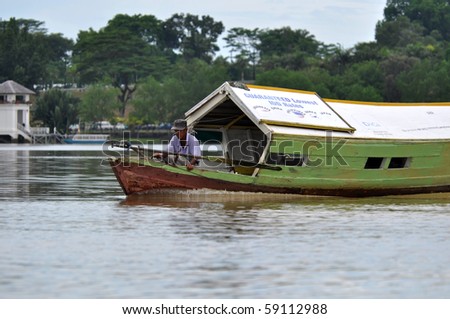 KUCHING, SARAWAK, BORNEO - MAY 4: Local boatman crosses the river to pick up the customers on May 4, 2010 in Kuching. Using of small boats is the only way how to cross the wide river.