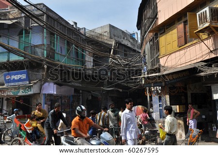 OLD DELHI, INDIA - OCTOBER 24: People travel under the risky and chaotic electrical wiring on October 24, 2009 in Old Delhi, India. Unsatisfying condition of wiring causes power problems in Delhi.