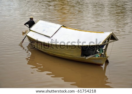 KUCHING, SARAWAK, BORNEO - 4 MAY: Local boatman crosses the river to pick up the customers on May 4, 2010 in Kuching, Borneo. Use of small boats is the only way to cross the wide river in Kuching.