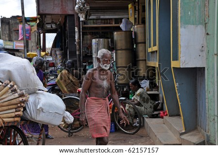 MADURAI, INDIA - NOV 7: Poor indian man nearly without dress walks on the street in Madurai on November 7, 2009. Poverty is the serious problem in the whole India.