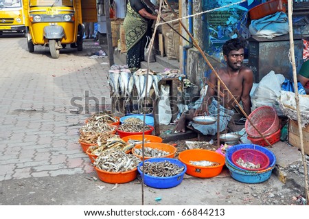MADURAI, INDIA - 6 NOVEMBER, 2009: An unidentified Indian man sell fishes on a street in Madurai on November 6, 2009 in Mudarai, India. Street bazaar is a common way how to sell and buy stuffs in India.