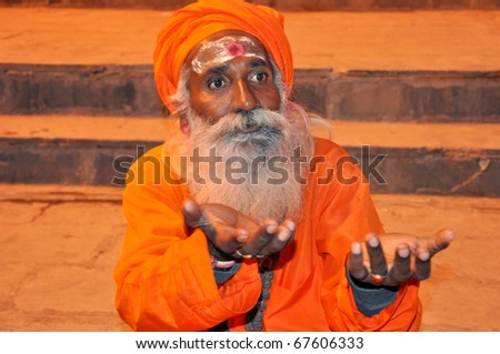 VARANASI, INDIA - OCTOBER 28: An unidentified Indian holy man meditates on the ghat near the river Ganga on October 28, 2009.  Holy Indian men dedicate their lives to worship and prayer.