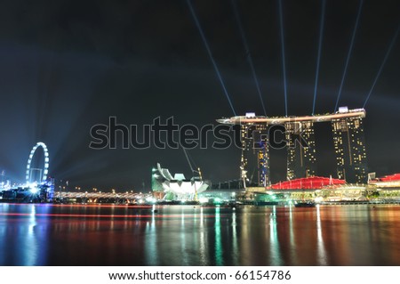 SINGAPORE - AUGUST 7: Buildings around Marina Bay shining beams of light during Singapore National day rehearsal at Marina Bay August 7, 2010 in Singapore