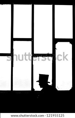 Silhouette of the man in black at the window