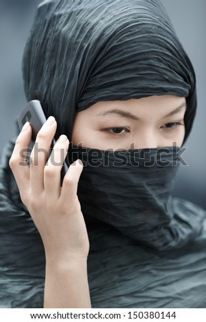 Muslim lady in hijab talking via cell phone Muslim lady in hijab talking via cell phone