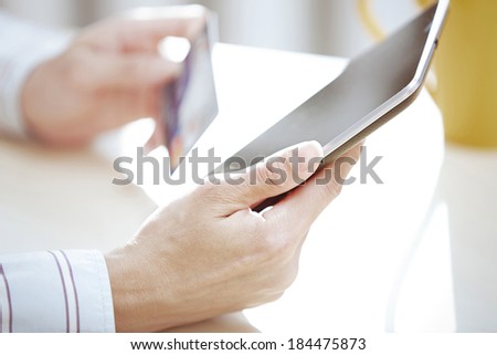 Human hands with tablet PC and credit card during lunch